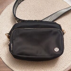 lululemon black crossbody with gold zipper and patterned strap